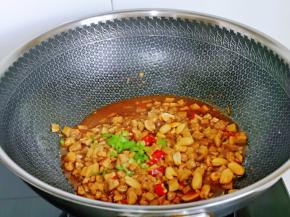 加入切好的红绿辣椒段，熟花生，大火快速翻炒1分钟，关火出锅。