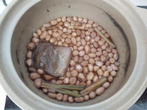 煮好的花生米浸在锅里放凉后再捞出来。