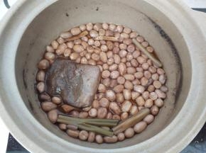 煮好的花生米浸在锅里放凉后再捞出来。