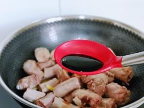 放入鸭脖段翻炒，加入生抽，料酒。