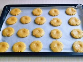 再分成等份的小面团，放入垫有油纸的烤盘中，并间隔距离，压扁，每个核桃酥胚约20g左右。