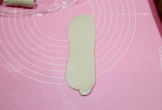 取一个卷，收口朝下，从中间往上或者往下，第二次擀开。