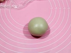 然后倒转过来，馅料朝下，将面皮贴到馅料球上，然后再翻转朝上，用右手虎口位置慢慢往上收口，口一定要收紧，不然烤的时候会爆的。包一个时候可以预热烤箱，上下180度。