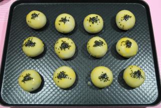 用毛刷刷一层蛋黄液，再撒上芝麻。