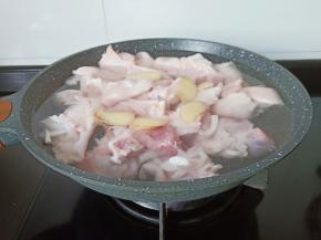 锅里加适量的清水，放入猪脚、生姜片、料酒少许。