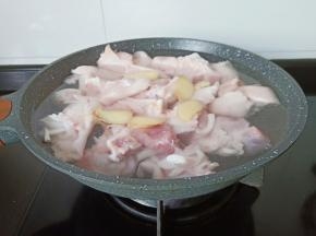 锅里加适量的清水，放入猪脚、生姜片、料酒少许。