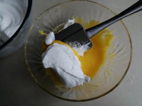 用刮刀取1/3打发好的蛋白霜到蛋黄糊里，从底部向上翻拌并切拌均匀