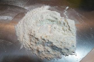 低筋面粉跟高筋面粉过筛后直接在揉面垫上简单拌匀，加入苏打粉、泡打粉跟臭粉，拌匀。（没有臭粉可忽略）