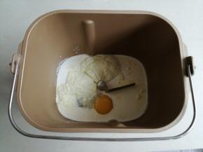 把牛奶、淡奶油、炼乳、蛋液都倒入面包桶里，对角放入糖和盐，倒入奶粉