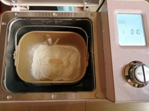 再倒入面粉，在面粉顶端加入酵母，把面包桶放入到启动东菱JD08面包机的和面程序，选择13分钟