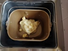 第一次和面结束后加入切成小块的黄油，继续选择和面18分钟