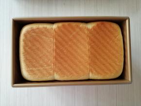 烘烤结束，把吐司盒取出来，在桌面上摔一下，摔出热气，然后把面包倒在烤架上晾凉，未食用的面包，可放在保鲜袋里扎紧口袋室温下保存