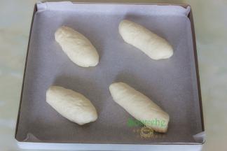 烤箱垫上硅油纸，把做好的面包均匀码入到烤盘上，烤箱放一盘温水，放入面包胚，时间设置40分钟，发酵至原来的2倍大。