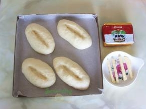 发酵好的面包胚，用剪刀，在面包上划出一个口，黄油切4个小长条，软化之后，放入面包剪好的口上。如果完全软化黄油，建议用挤压的方式，在面包切口上。