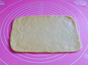 取一块静置好的面团，用擀面杖擀出长方形。