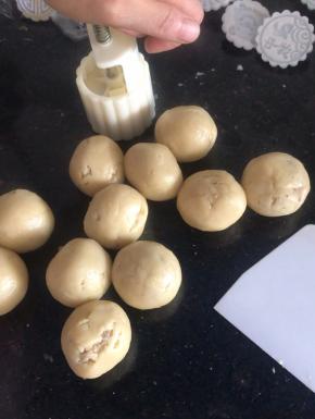 把月饼模具扣入圆球上，按压一下，再按压提起脱模（同时200度预热烤箱10分钟）