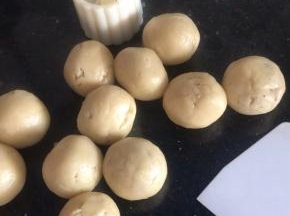把月饼模具扣入圆球上，按压一下，再按压提起脱模（同时200度预热烤箱10分钟）