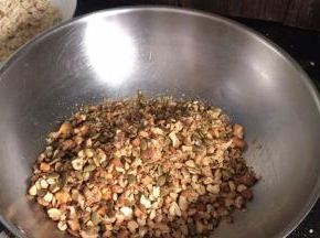 备一个大点的不锈钢容器，先把粗点的果仁倒入容器中
