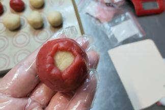 一点一点慢慢收紧，在顶部留一个小口。（在这个过程中一定注意要馅料跟皮完全贴紧，否则进入空气，做好的月饼会走型）