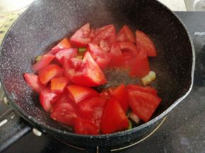 锅里加油烧热后，倒入姜蓉炒香，再倒入西红柿块