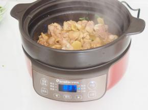 电炖锅选择煎焗模式，倒入适量油，热后放入葱花煸炒片刻，然后倒入鸡块煸炒至颜色发白。