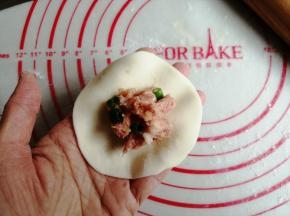 擀成四周薄中间厚的圆面皮，中间放上馅料