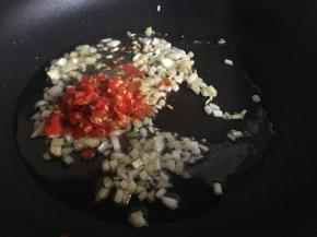 起锅热油，倒入生姜、大蒜、葱白、剁辣椒煸香；