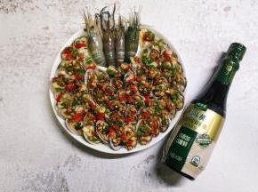 将混合调料均匀淋入花甲上，再撒上青、红椒碎