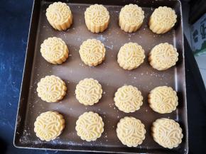 表面抹少许玉米淀粉，月饼模具也过一遍粉防粘，印好图案，摆入烤盘，放冰箱冷藏半小时