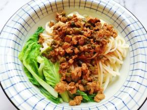 将准备好的面条盛入碗里。浇上豇豆鸡肉酱。