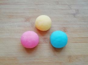 分别加入西瓜口味固体饮料粉（粉色）、凤梨口味固体饮料粉（黄色）和蓝莓口味固体饮料粉（蓝色），揉成不同颜色的面团。