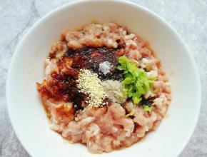 加入老抽、糖、蚝油、盐、白胡椒粉，鸡精和小葱叶搅拌均匀。