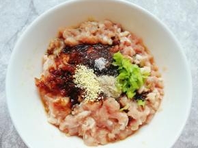 加入老抽、糖、蚝油、盐、白胡椒粉，鸡精和小葱叶搅拌均匀。