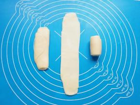 将卷好的油酥皮收口朝上轻压，擀开再次卷起，收口朝下摆放。