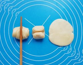 松弛好的卷卷用筷子从中间压一下，两头向上压扁，擀成圆形的酥饼皮。