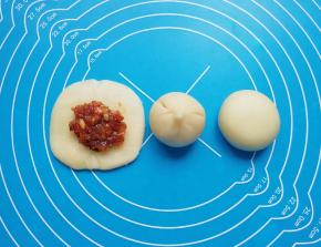 放上肉馅，用虎口慢慢向上推挤收口，将收口捏紧，反过来收口朝下摆放，用手掌轻轻压平成饼状。