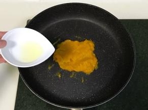南瓜泥入不粘锅中，分三四次加入糖粉和玉米油翻炒，南瓜泥会越来越稠。