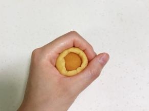 取一个面团按扁，放上一份南瓜馅，利用虎口收紧，搓成椭圆形，依次完成。