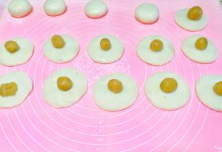 揉成饼状，放入搓成圆球的馅料，包好收口。放手粉中滚一圈。