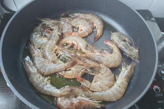 海虾平铺放入锅内，转中火煎红。