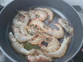 海虾平铺放入锅内，转中火煎红。