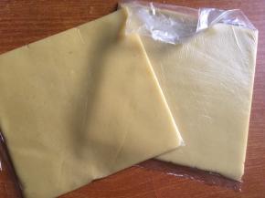 将面团平均分成2份，连同豆沙一起分别放入保鲜袋或者油纸中，借助擀面装干成相同大小的方片；（如果怕面片太软不好操作，也可放入冰箱中冷藏半小时左右）

