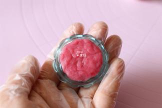 取少许红色面团压入月饼模具的花片纹路中；