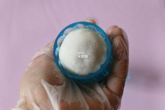 再放入包好馅的白色面团（为了防粘事先在熟糯米粉里翻滚一下），倒过来放在垫子上，轻轻一压再脱模即可；