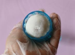 再放入包好馅的白色面团（为了防粘事先在熟糯米粉里翻滚一下），倒过来放在垫子上，轻轻一压再脱模即可；