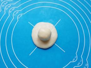 取一个油皮面团压扁，放上油酥面团包好。