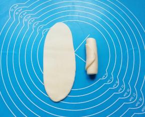 包好的油酥皮擀开，然后卷起来。