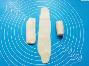 将卷好的油酥皮收口朝上轻压，擀开再次卷起，收口朝下摆放。