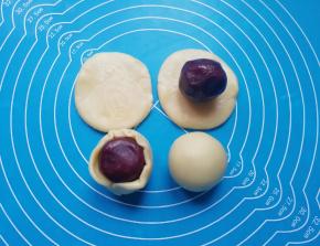 取一个擀好的饼皮，包入蛋黄豆沙馅，用虎口慢慢向上推挤收口，最后将收口朝下摆放，蛋黄酥就包好了。