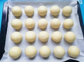 烤盘上铺油纸，放上做好的蛋黄酥。